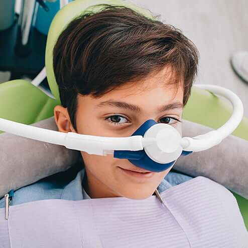 young boy with a nitrous oxide mask on his face
